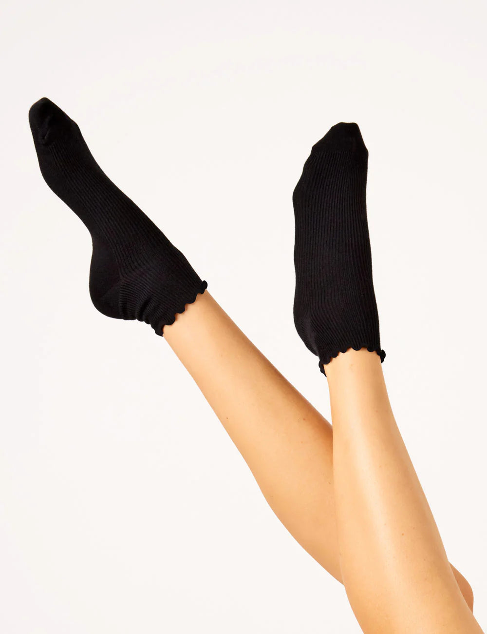 Image of legs up in air with black socks on gray background