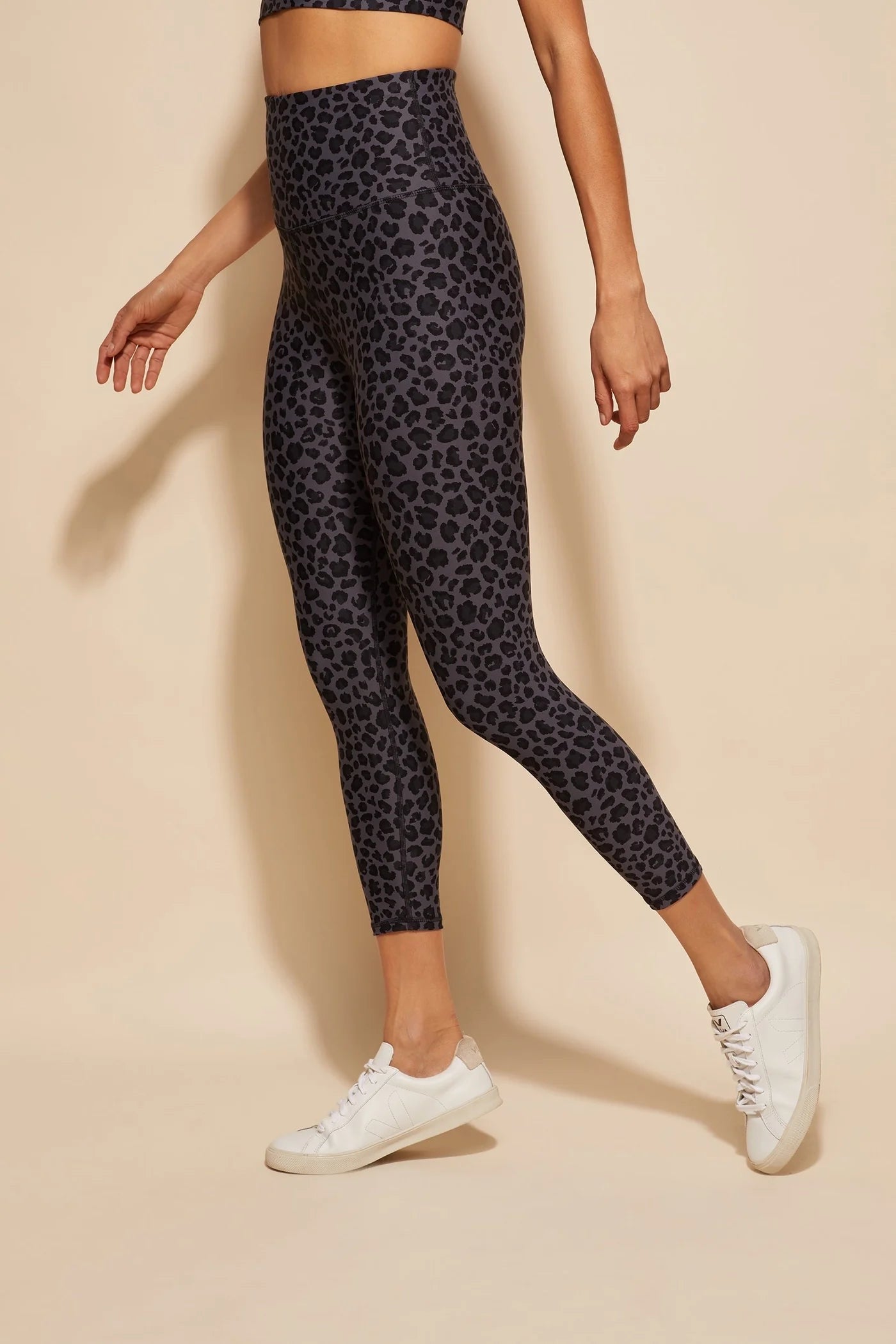 Leopard patter tights a human wearing them with white shoes on